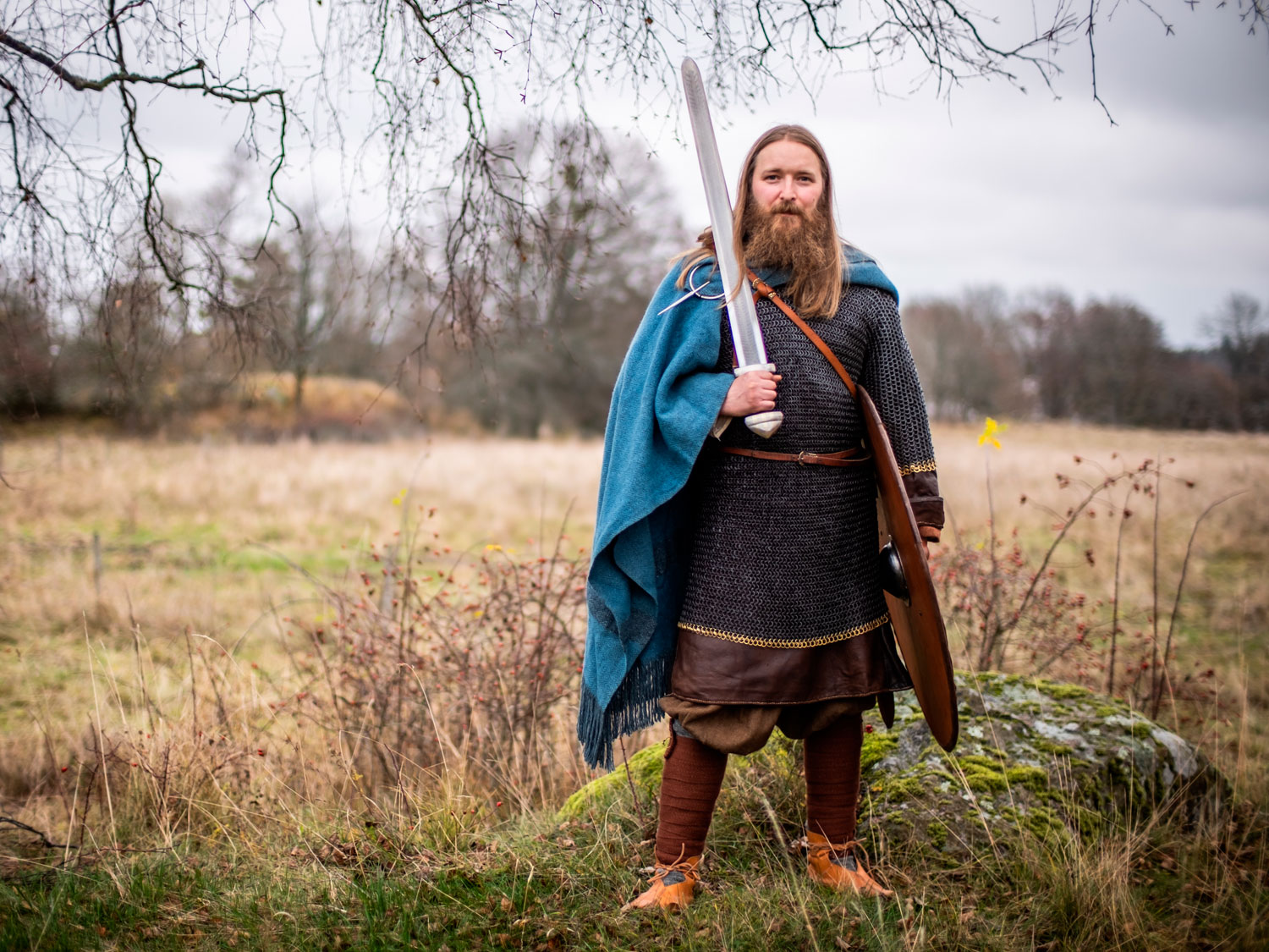 En man utklädd till viking håller i ett svärd. 