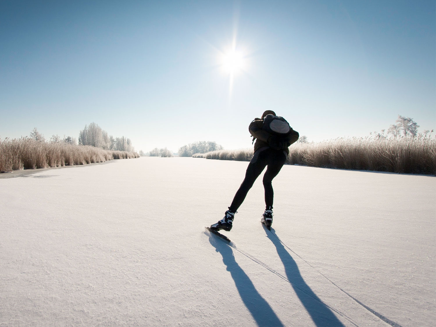 En person åker långfärdsskridskor ensam på en frusen sjö