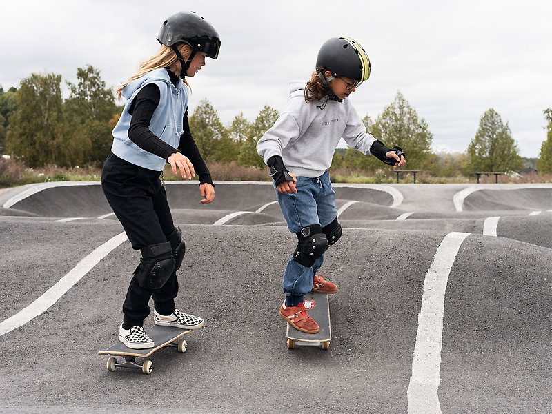 Två flickor åker skateboard.