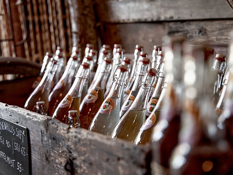 En trälåda med glasflaskor fyllda med dryck