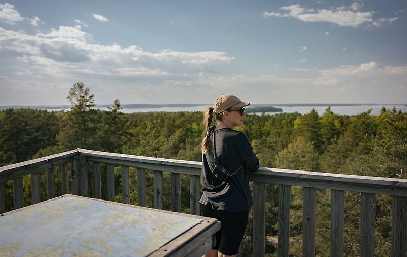 En kvinna står uppe i ett utkikstorn och tittar på utsikten.