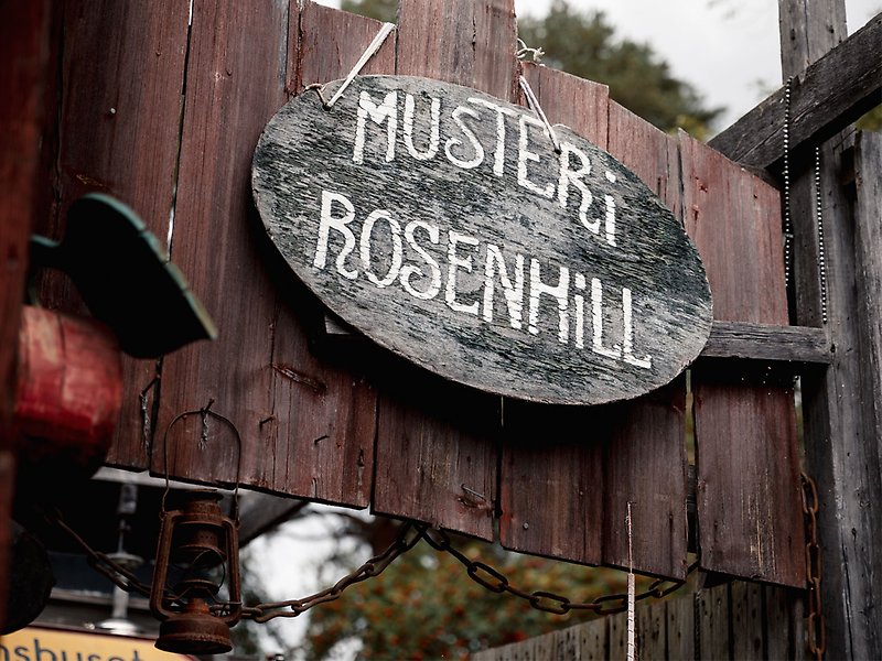 En skylt där det står Musteri Rosenhill hänger på en ladugårdsvägg
